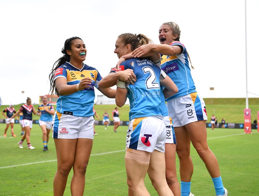 Karina Brown is swamped by her Titans team-mates after scoring a try in the club's first ever win.